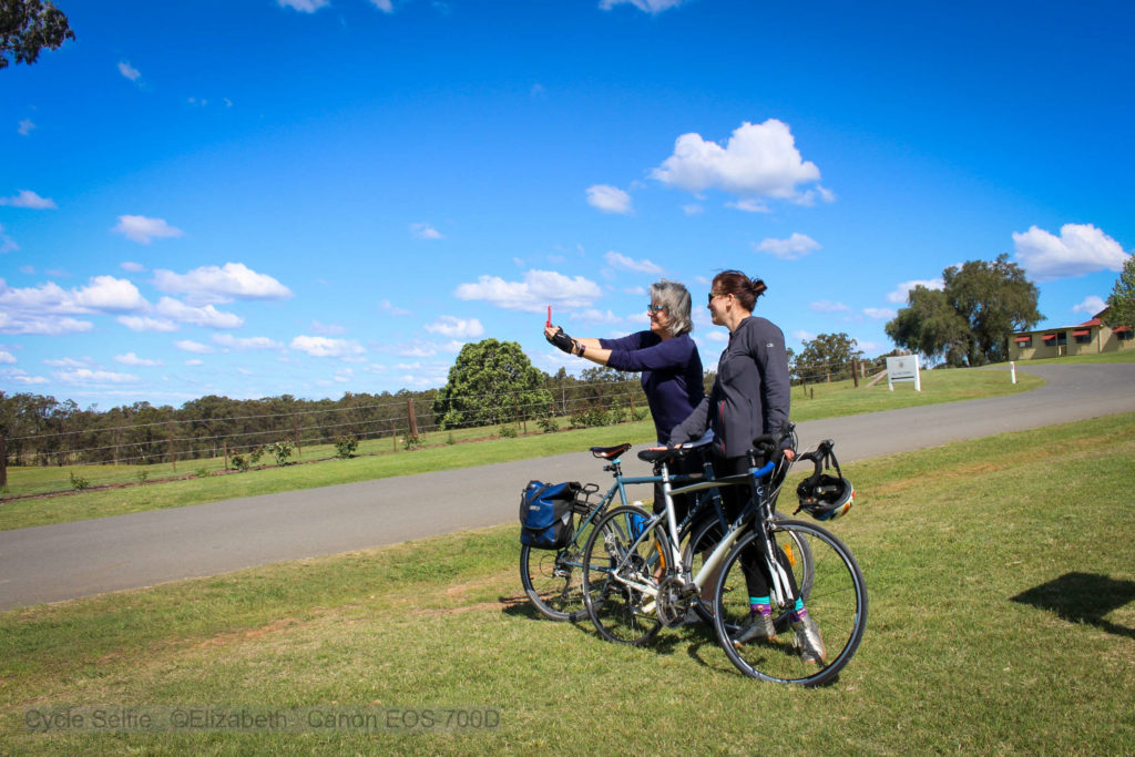 Girls on bikes taking selfie with vines in the background