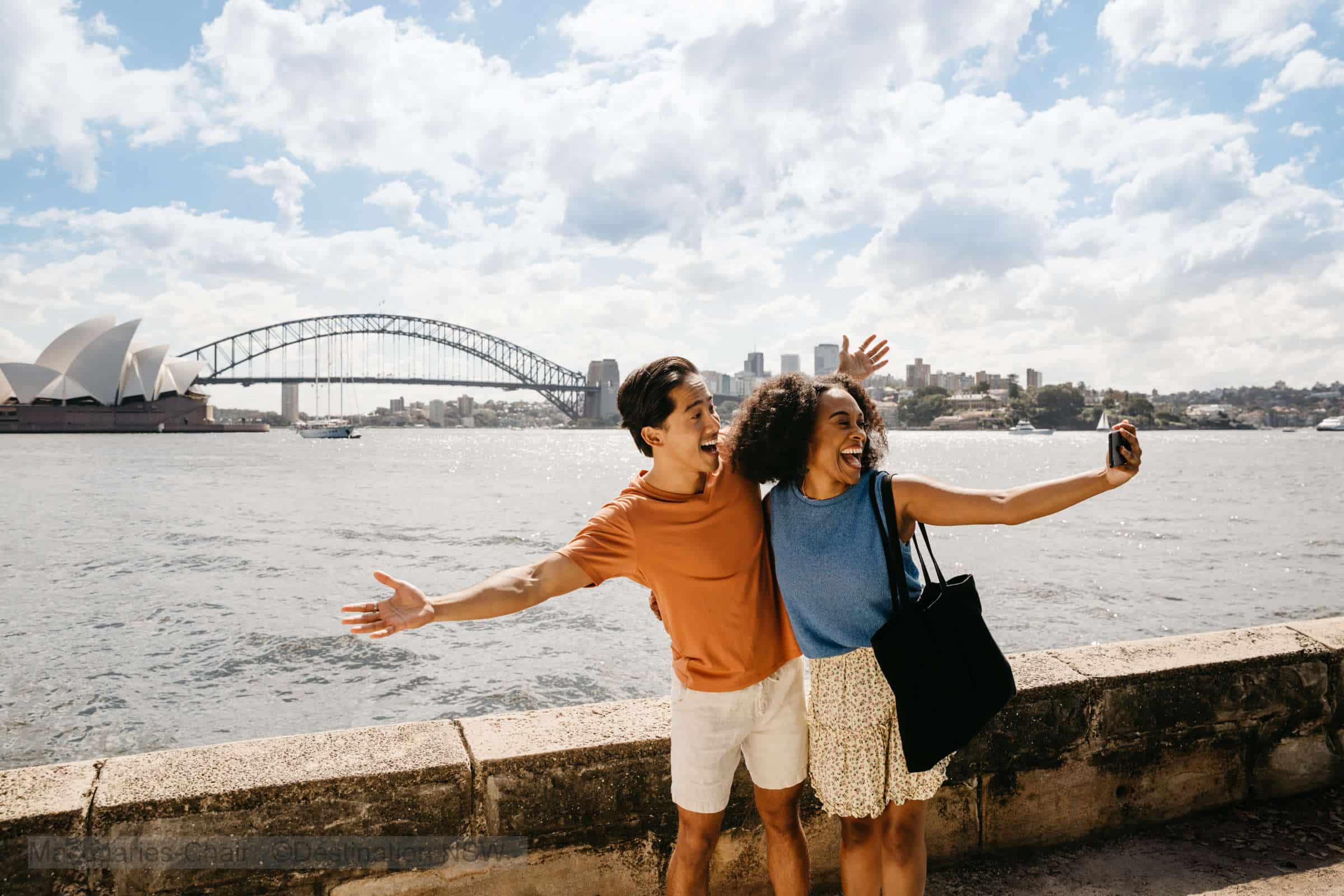 couple at Mrs. Macquarie's chair overlooking the Opera House and Sydney Harbor Bridge