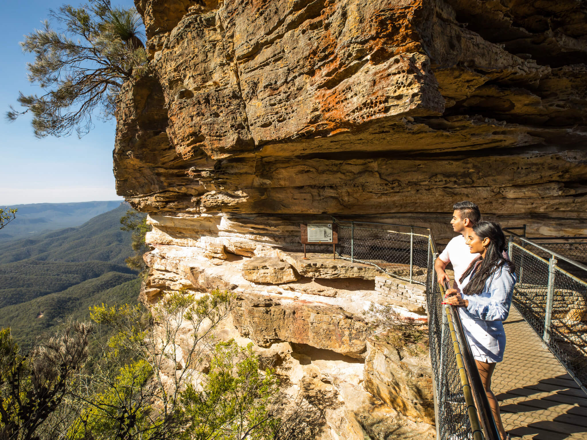 Couple enjoying views from Honeymoon Bridge overlooking the Jamison Valley along the Three Sisters Walking Trail, Katoomba.
