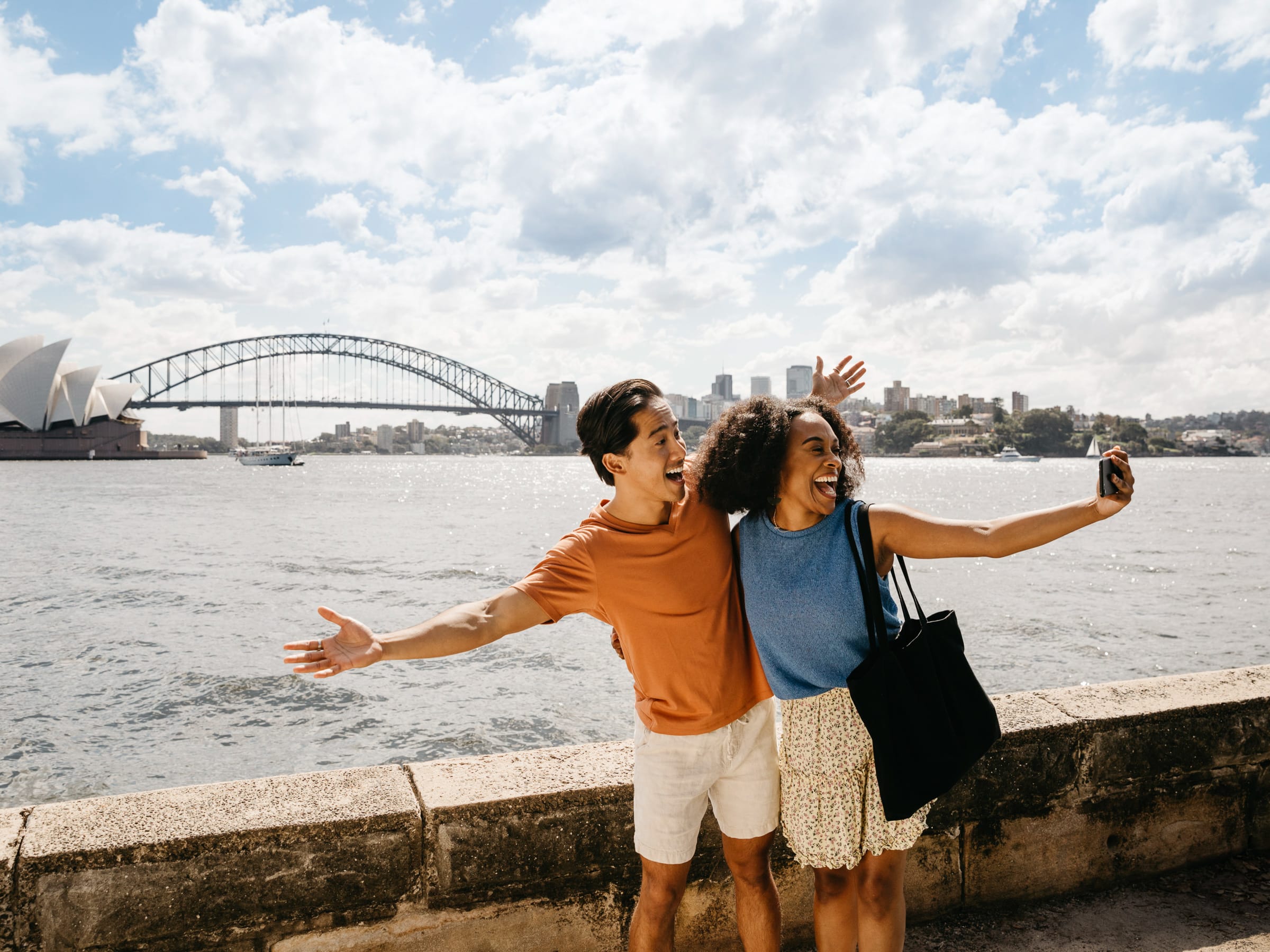 A couple taking a Selfie at Lady Maquaries chair with the harbour bridge in the background.