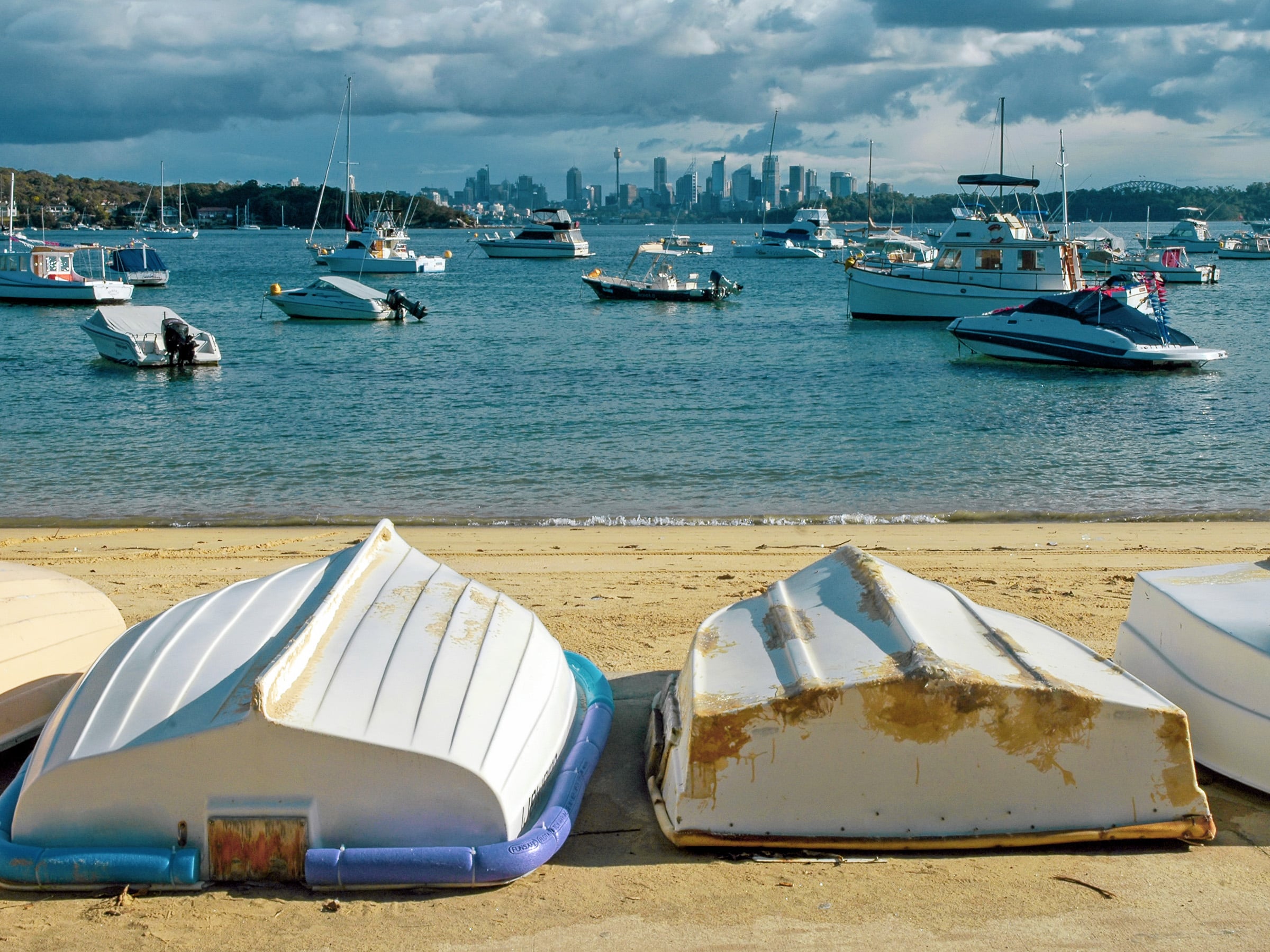 Whatsons Bay dingys on the beach looking back to Sydney city skyline